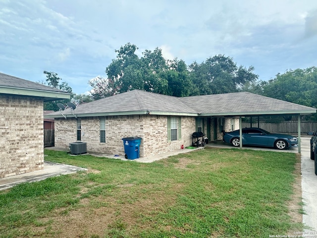 back of house featuring a carport, a yard, and central AC unit