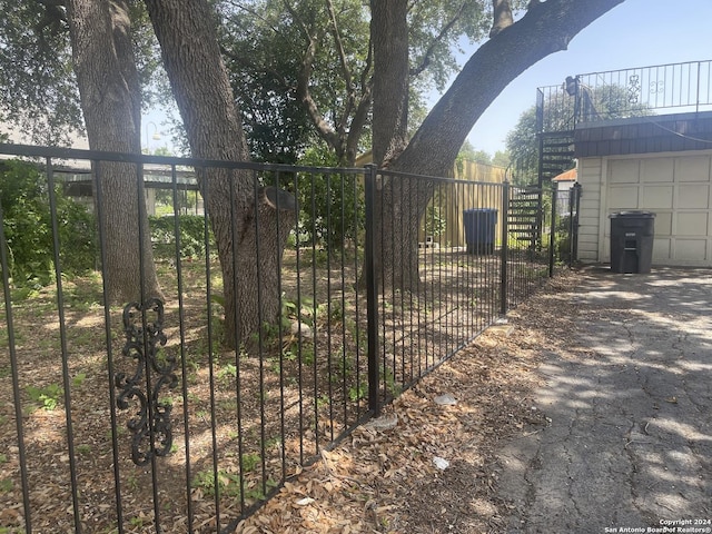 view of gate featuring stairway and fence