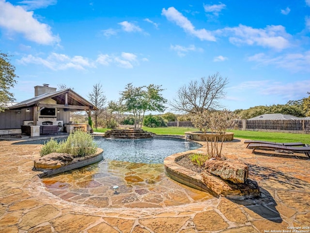 view of swimming pool with fence, a patio, and an outdoor fireplace