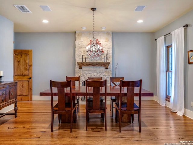 dining area featuring wood finished floors, visible vents, and an inviting chandelier