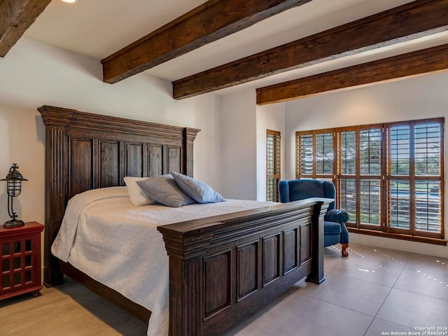 bedroom featuring light tile patterned floors and beam ceiling