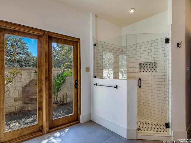 full bath featuring tile patterned flooring, a shower stall, and baseboards