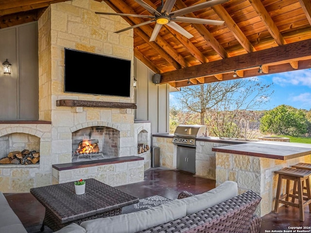 view of patio / terrace featuring ceiling fan, an outdoor kitchen, a sink, grilling area, and an outdoor living space with a fireplace