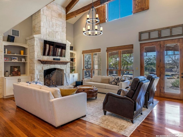 living area featuring a stone fireplace, wood finished floors, and visible vents