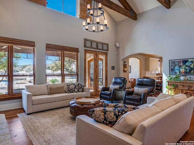 living room with arched walkways, a chandelier, wood finished floors, high vaulted ceiling, and beam ceiling