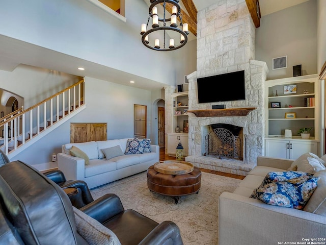 living area with arched walkways, a stone fireplace, a high ceiling, visible vents, and stairway