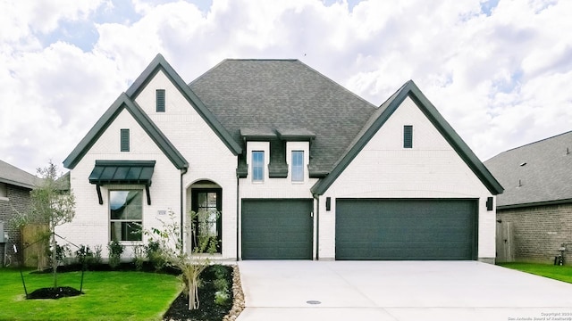 view of front of home featuring a garage and a front lawn