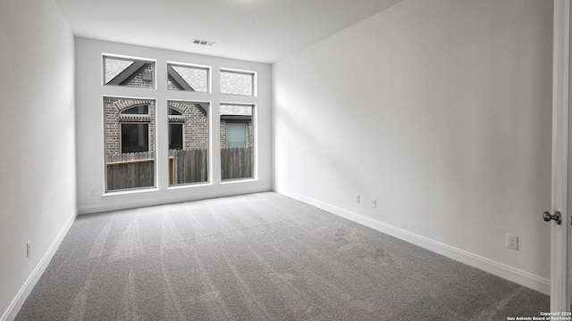 carpeted spare room featuring a fireplace