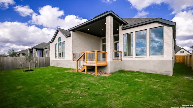 rear view of property featuring a lawn