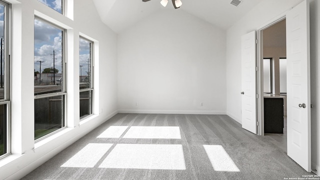 empty room with plenty of natural light, light colored carpet, and vaulted ceiling