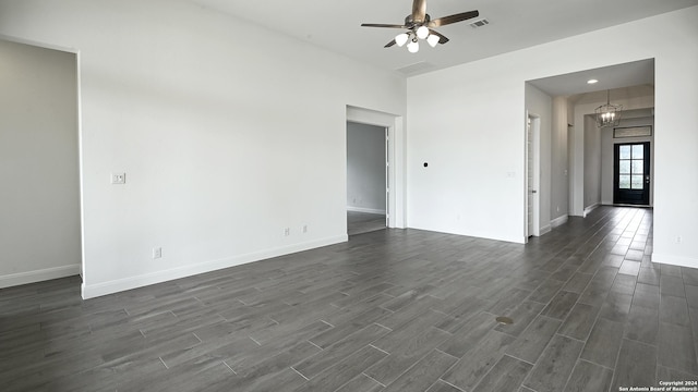 spare room featuring dark hardwood / wood-style flooring and ceiling fan with notable chandelier