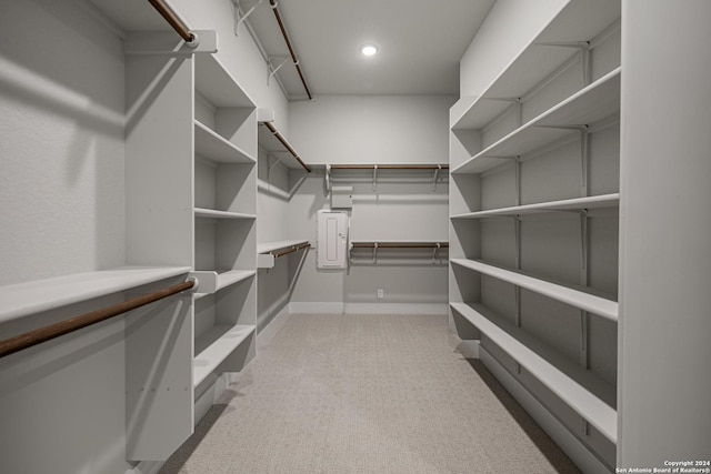 walk in closet featuring light carpet