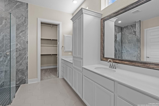 full bathroom with visible vents, a walk in closet, a walk in shower, tile patterned flooring, and vanity