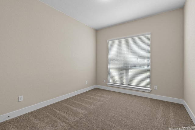 empty room featuring baseboards and carpet floors