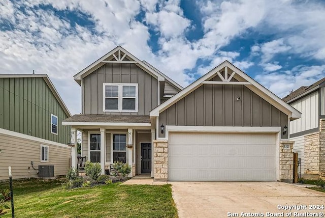 craftsman house with cooling unit, a garage, and a front lawn