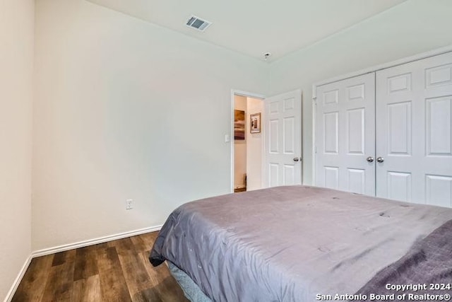 bedroom featuring dark wood-type flooring and a closet