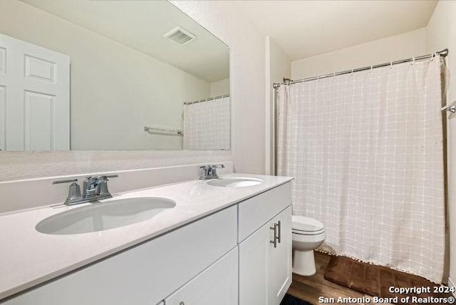 bathroom featuring vanity, hardwood / wood-style floors, and toilet