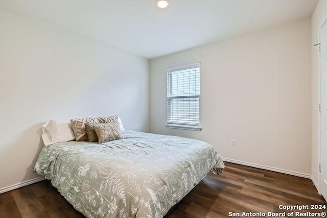 bedroom with dark hardwood / wood-style floors