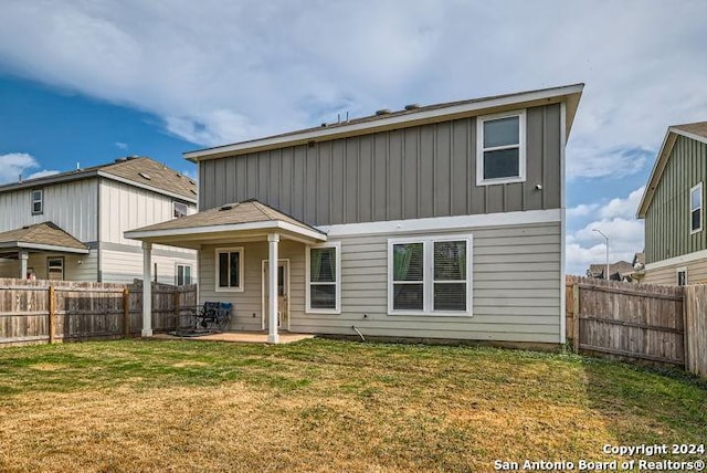 back of property with a yard and a patio