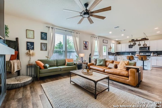 living room featuring hardwood / wood-style flooring and ceiling fan