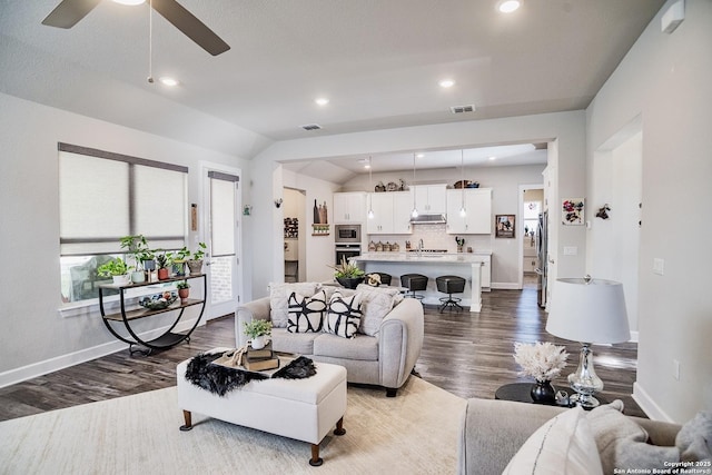 living room with hardwood / wood-style flooring, ceiling fan, lofted ceiling, and sink