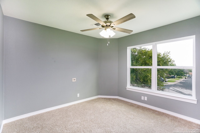 carpeted spare room with ceiling fan