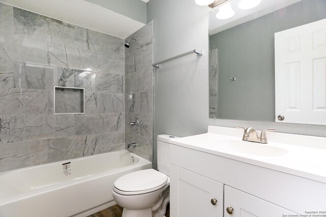 full bathroom with tiled shower / bath combo, vanity, and toilet