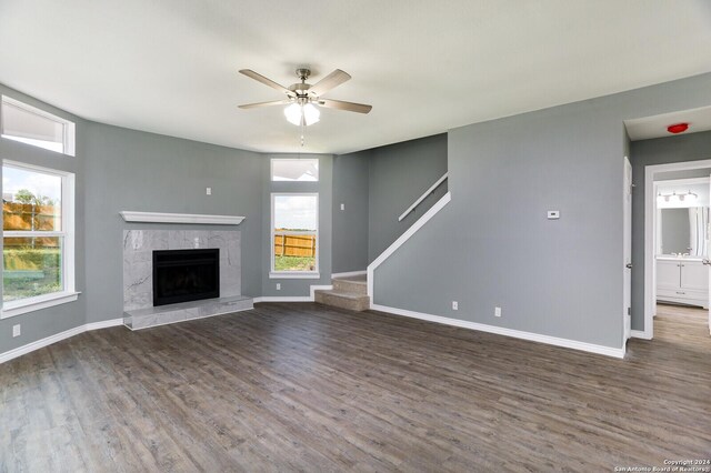 unfurnished living room with a fireplace, ceiling fan, and wood-type flooring