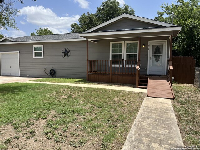 ranch-style home featuring a garage, covered porch, and a front lawn