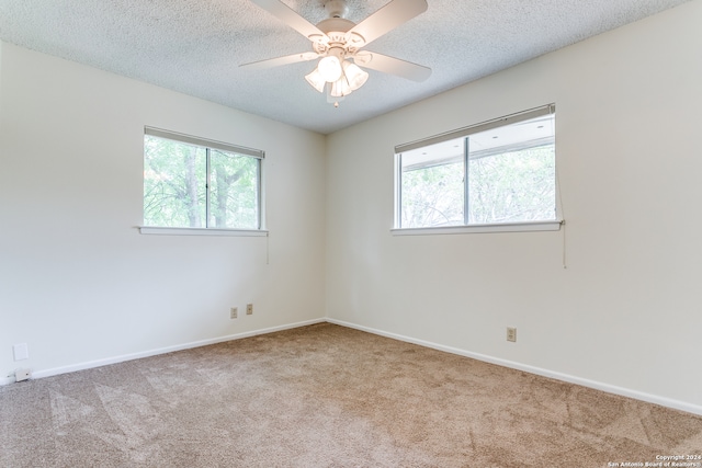 carpeted empty room featuring a textured ceiling and ceiling fan