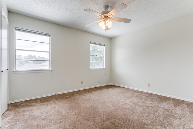 carpeted empty room featuring a textured ceiling and ceiling fan