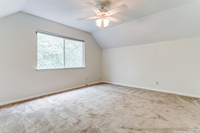 bonus room with a textured ceiling, vaulted ceiling, carpet floors, and ceiling fan