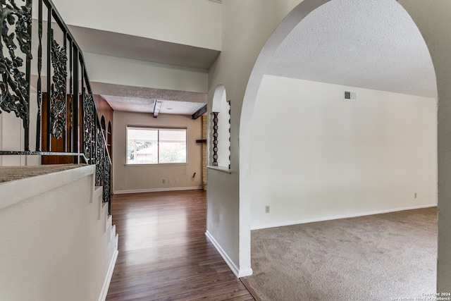 hall with carpet floors and a textured ceiling