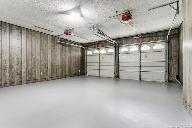 garage featuring wood walls and a garage door opener