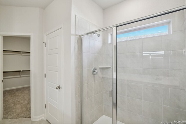 bathroom with an enclosed shower and tile patterned floors