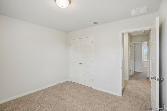 unfurnished bedroom featuring a closet and light carpet