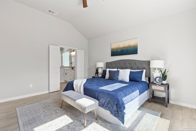 bedroom featuring light wood-type flooring, vaulted ceiling, ceiling fan, and ensuite bathroom