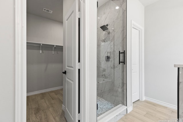 bathroom featuring wood-type flooring and walk in shower