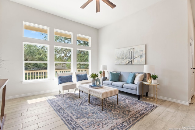 living room with light hardwood / wood-style floors, ceiling fan, and a healthy amount of sunlight