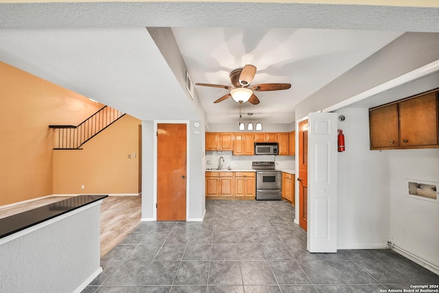 kitchen featuring stainless steel appliances, sink, tile patterned floors, and ceiling fan