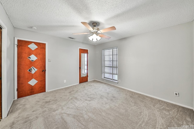 carpeted entrance foyer featuring a textured ceiling and ceiling fan