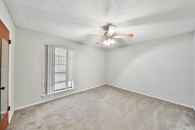 spare room with ceiling fan, carpet flooring, and a textured ceiling