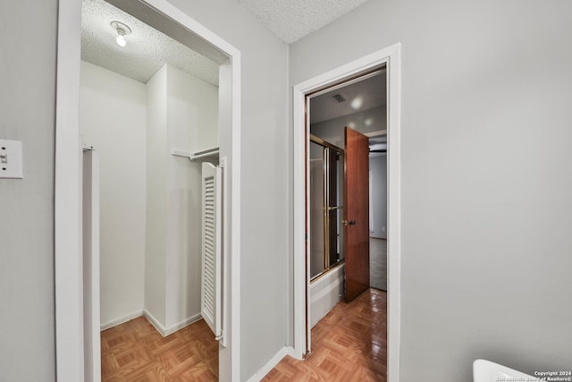 bathroom featuring parquet floors and a textured ceiling