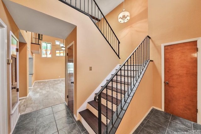 stairs featuring tile patterned flooring and a towering ceiling