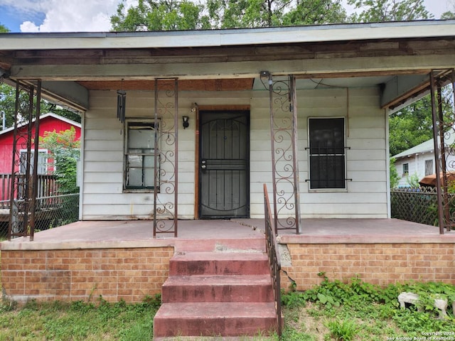 view of exterior entry featuring covered porch