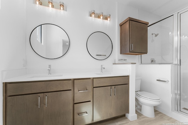 bathroom with an enclosed shower, vanity, hardwood / wood-style floors, and toilet