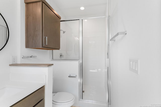 bathroom featuring vanity, toilet, and a shower with door