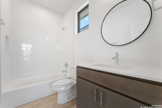 full bathroom featuring hardwood / wood-style flooring, washtub / shower combination, vanity, and toilet