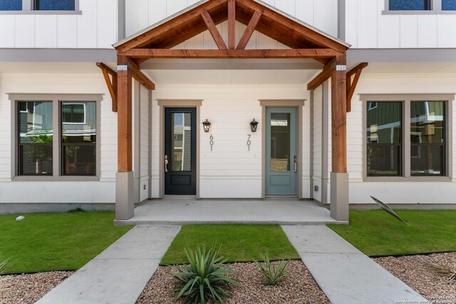 entrance to property featuring a lawn