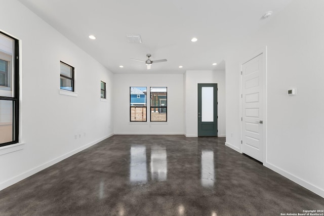 spare room with a ceiling fan, recessed lighting, finished concrete flooring, and baseboards